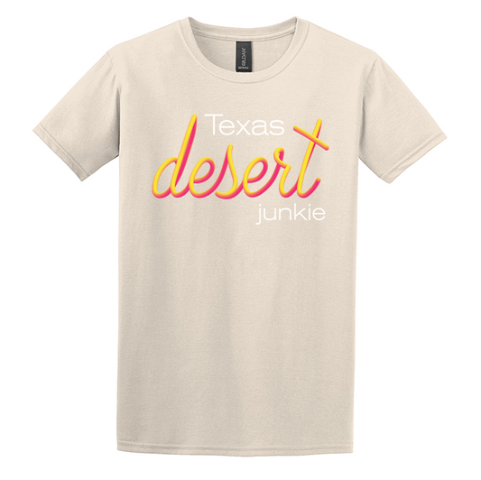 natural colored tan gildan softstyle t-shirt screen printed with texas desert junkie pink and yellow sunset vibrant print blended together like a sunset fade twisting around the words.